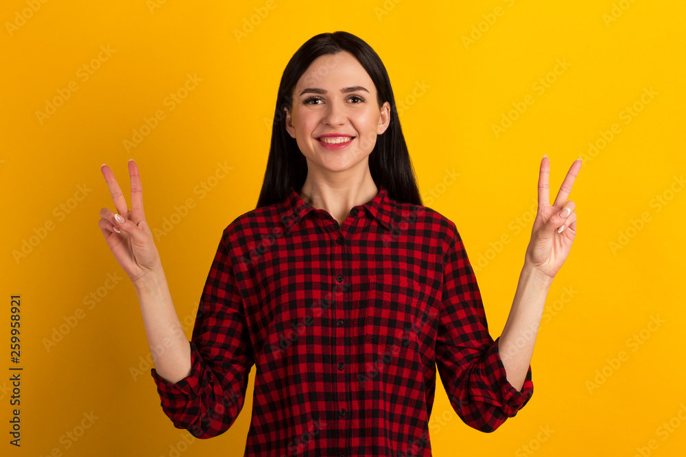 Close up photo beautiful amazed lady fingers show v-sign toothy beaming smiling pretty nice wearing casual red shirt isolated yellow bright background Close up photo beautiful amazed lady fingers show v-sign toothy beaming smiling pretty nice wearing casual red shirt isolated yellow bright background