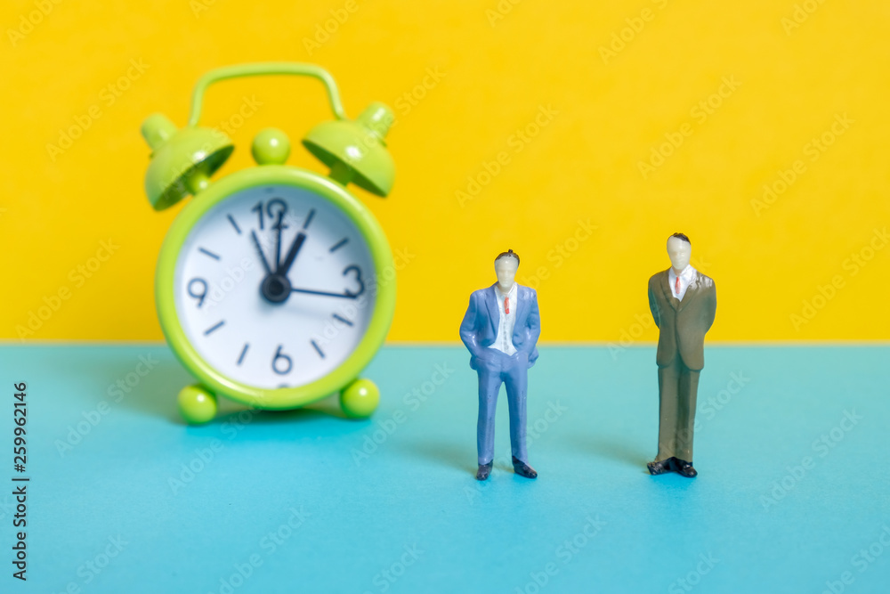 Men dummy next to a green vintage clock on a yellow background.