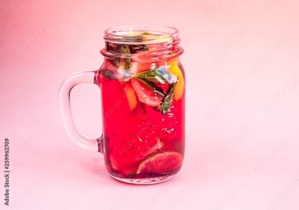 Jar of tasty cold lemonade on a pink background Jar of tasty cold lemonade on a pink background
