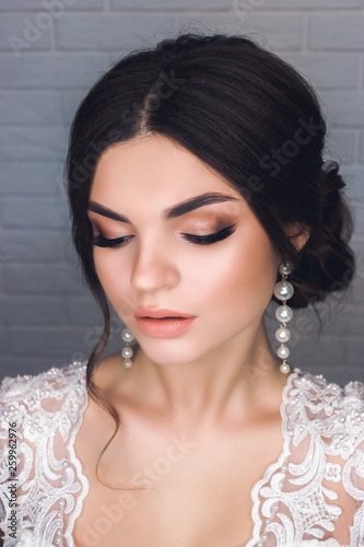 Makeup for the bride. Portrait of beautiful modest shy and very cute girl with brown hair and light eyes in Studio, close-up