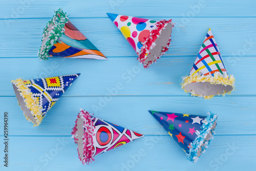Set of party hats on blue background. Composition with various party caps on blue wooden planks with text space.