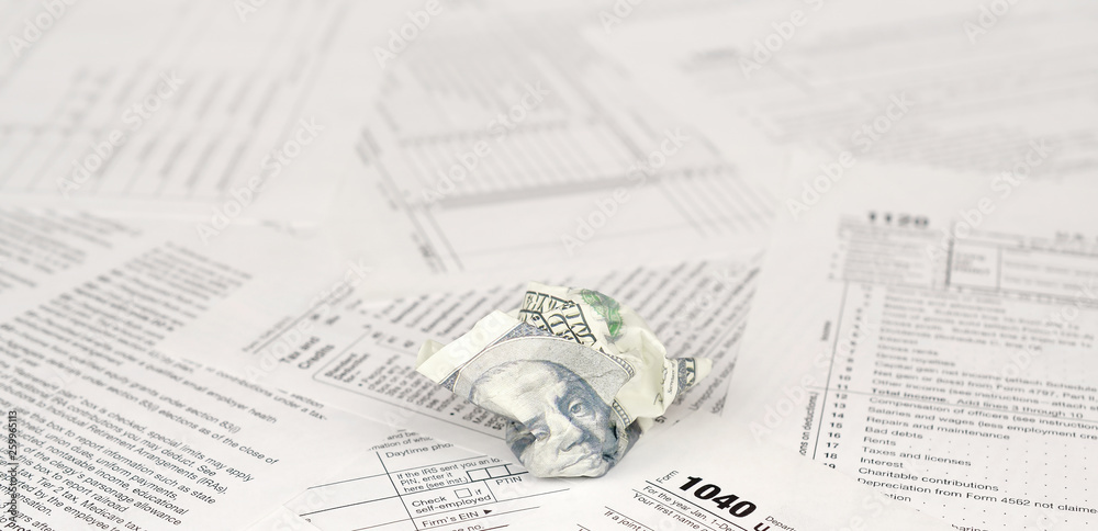 1040 Individual Income Tax Return Form And Crumpled Hundred Dollar Bill 1040-individual-income-tax-return-form-and-crumpled-hundred-dollar-bill