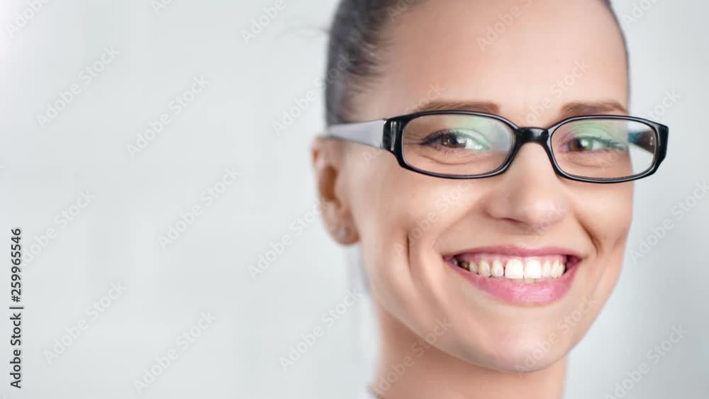 Close-up face of smiling beautiful business woman wearing glasses isolated at white studio Close-up face of smiling beautiful business woman wearing glasses isolated at white studio