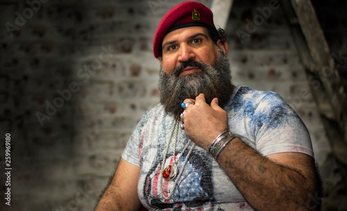 Ein Mann mit Bart, rotem Hut und Ringen aus Edelsteinen, Ketten und Accessoires © Arnaoty