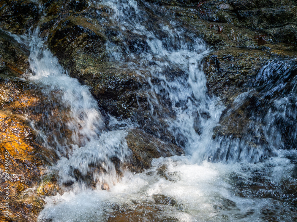 Water flows over the rocks of the waterfall on Koh Phangan. Thailand Water flows over the rocks of the waterfall on Koh Phangan. Thailand