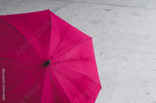 Pink farbener, offener Regenschirm stehend