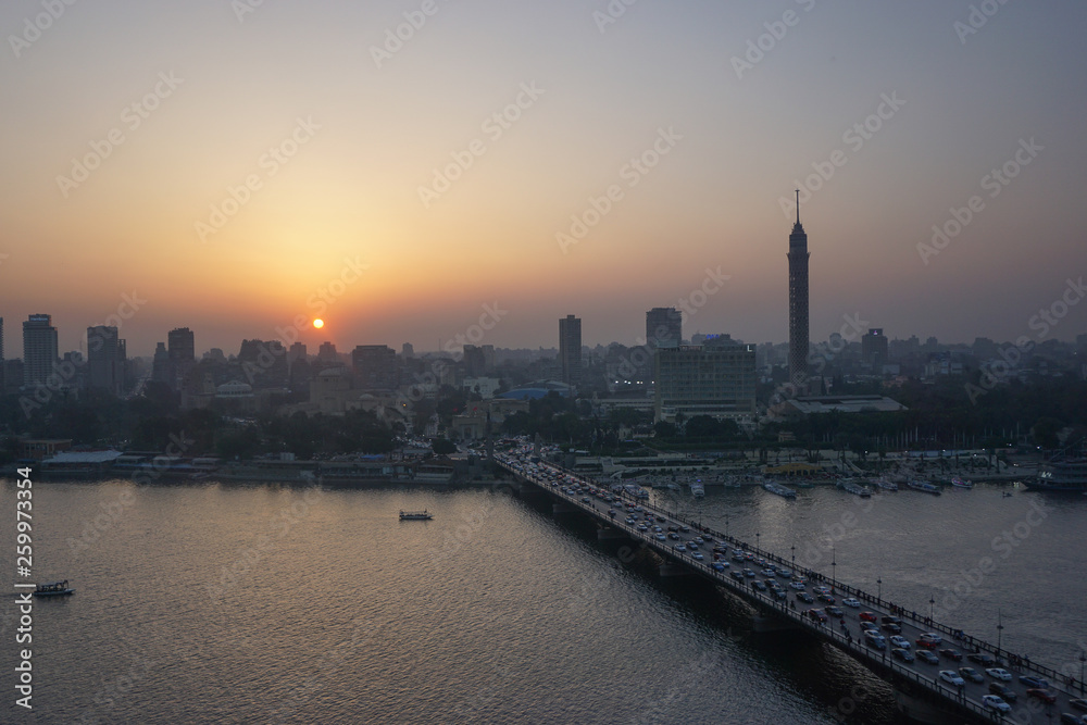 Cairo, Egypt: Cairo Tower and the Qasr el Nile Bridge at sunset. On Gezira Island in the River Nile, the tower is the tallest structure in Egypt.