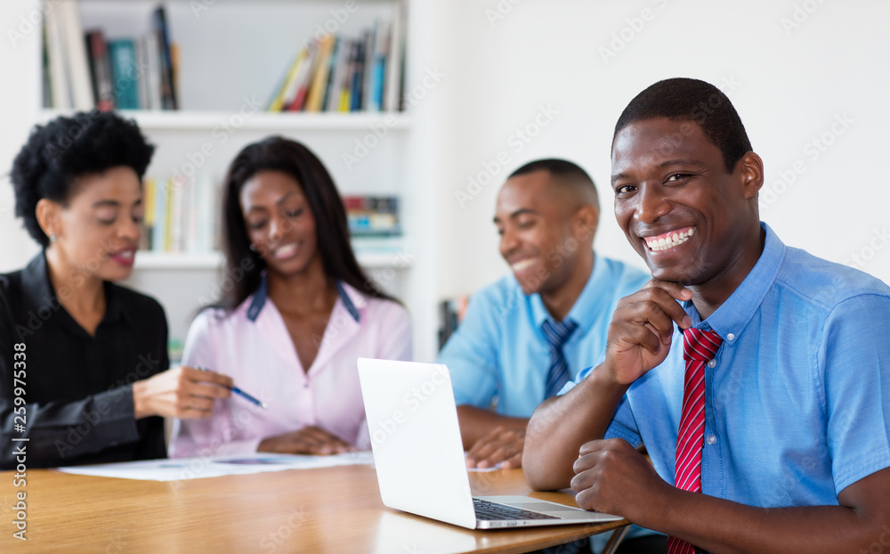Laughing african american businessman with team and computer Laughing african american businessman with team and computer