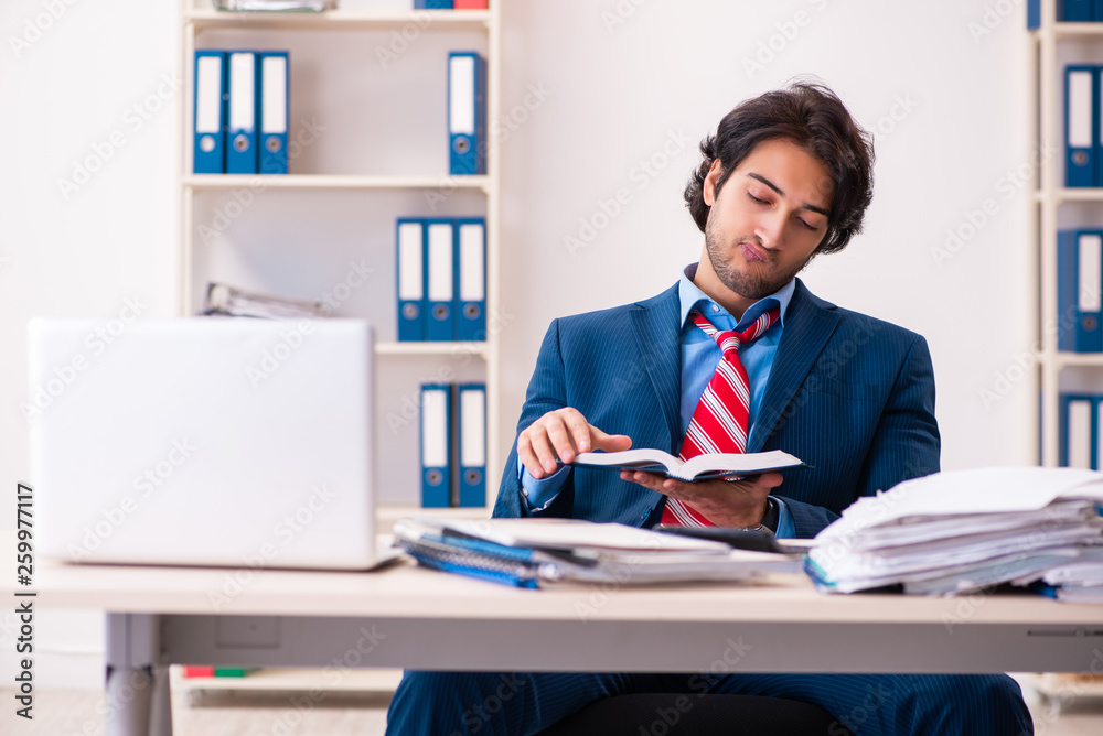 Young handsome businessman sitting in the office Young handsome businessman sitting in the office