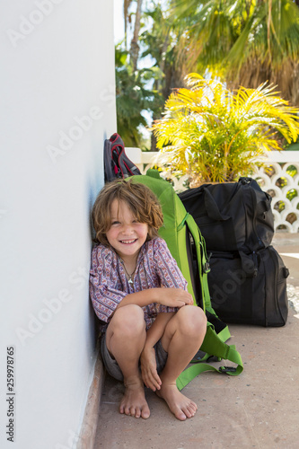 portrait of 5 year old boy leaning on travel luggage, Todos Santos, Mexico
