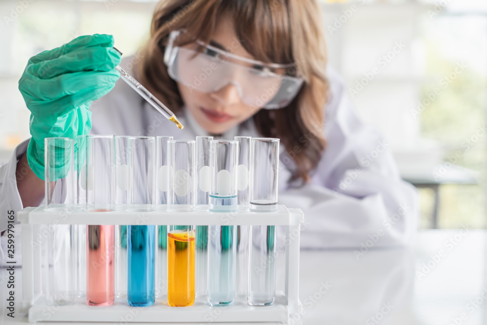 A young Asian woman scientist working in laboratory with test tube microscope and solutions. A young Asian woman scientist working in laboratory with test tube microscope and solutions.