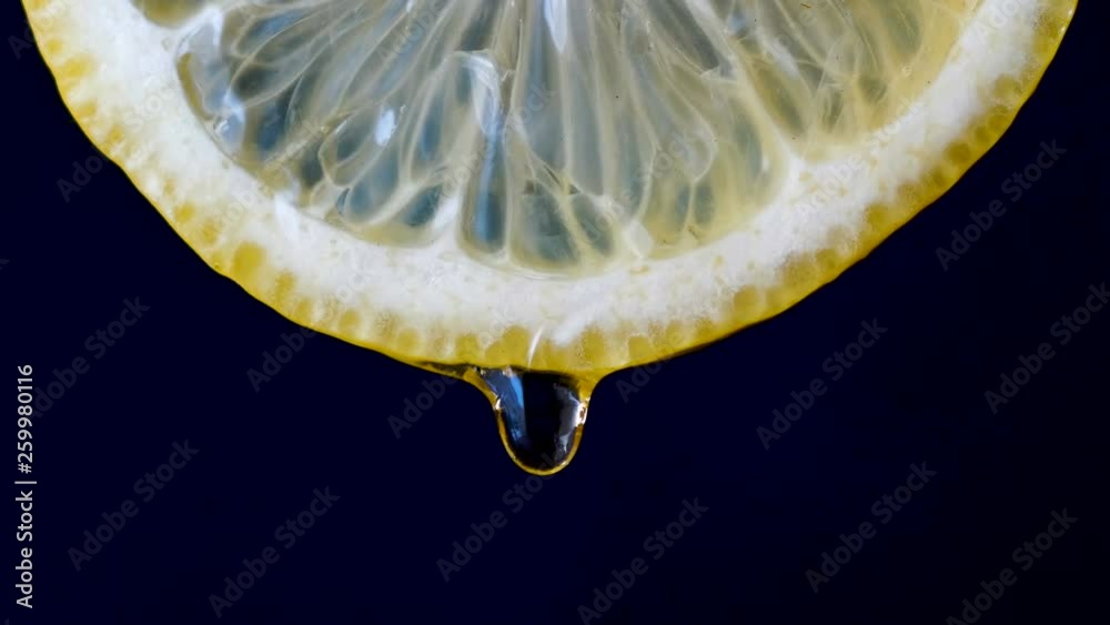 Honey on half lemon dripping on black background