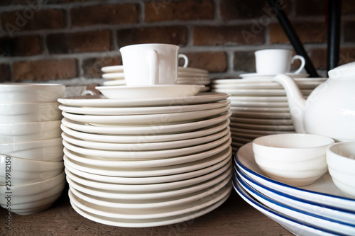 Many white plates are stacked together.a stack of white dish .