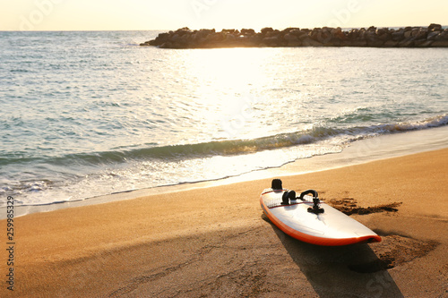 surfboard on sandy beach during sunset time © tomertu