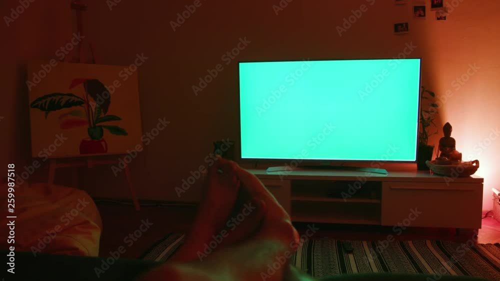 Couple’s feet touching lying on the bed watching TV. Loving woman and man relaxing after work. Couple’s feet touching lying on the bed watching TV. Loving woman and man relaxing after work.