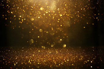 glitter vintage lights background. black and gold. de-focused