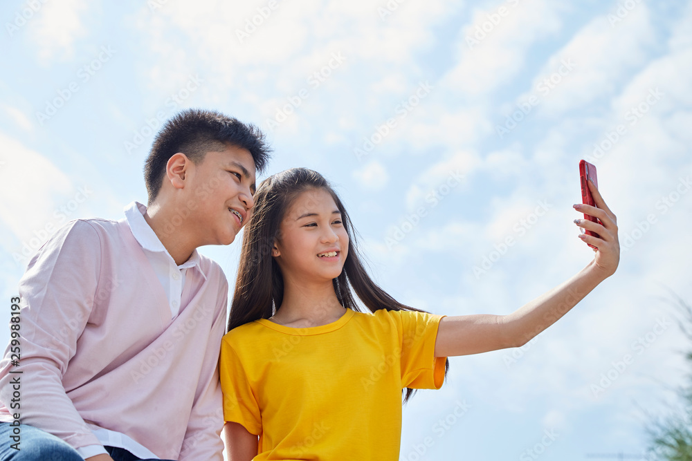 asian couple taking a selfie outdoor asian couple taking a selfie outdoor