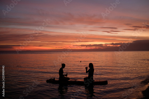 Two girls on a paddleboard during sunset