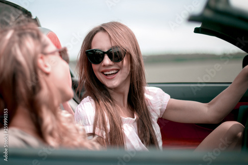 two girlfriends in a convertible car © ASDF