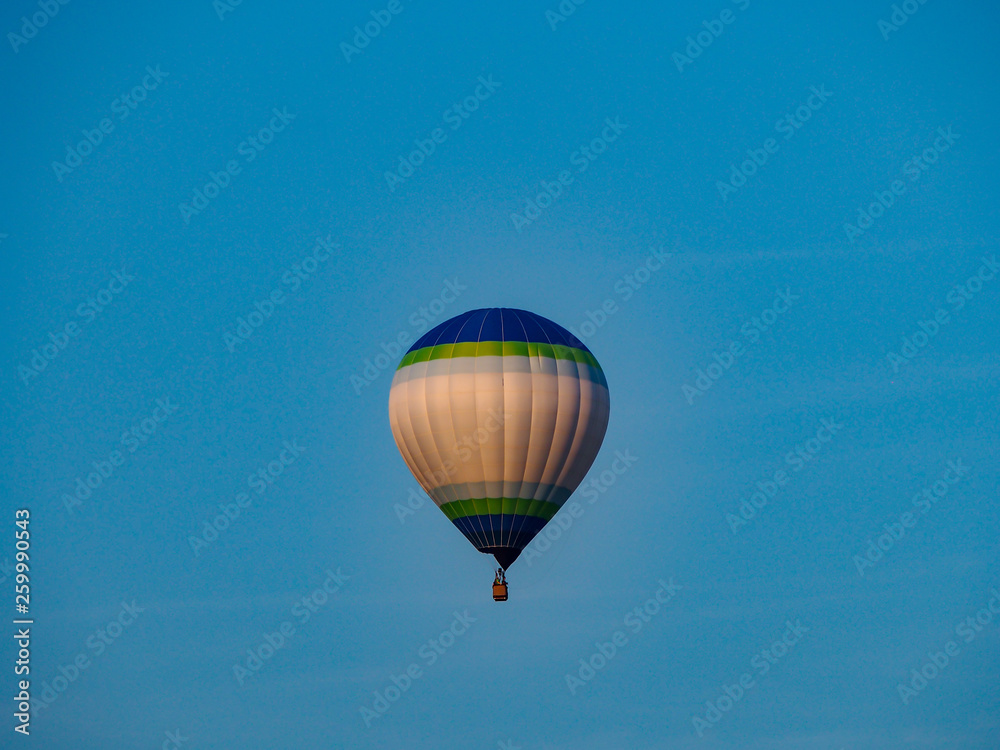 Naklejka premium Blue Green White Hot Air Balloon Blue Sky