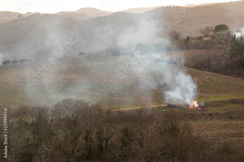 Fire burning on a brown farmland in Tuscany, Italy