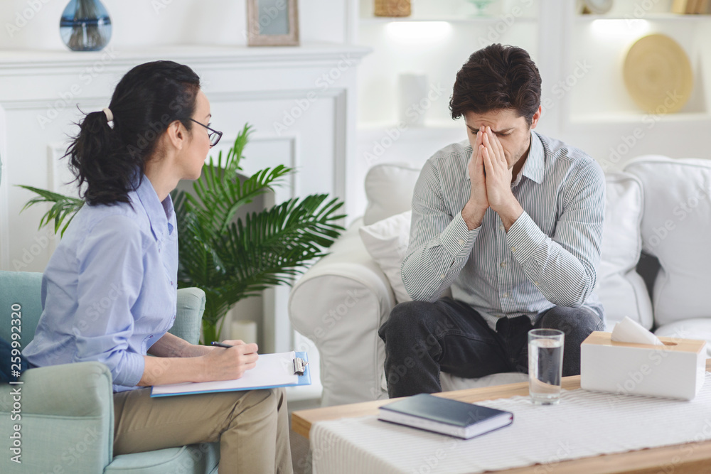 Depressed man emotionally speaking at psychotherapist session Depressed man emotionally speaking at psychotherapist session