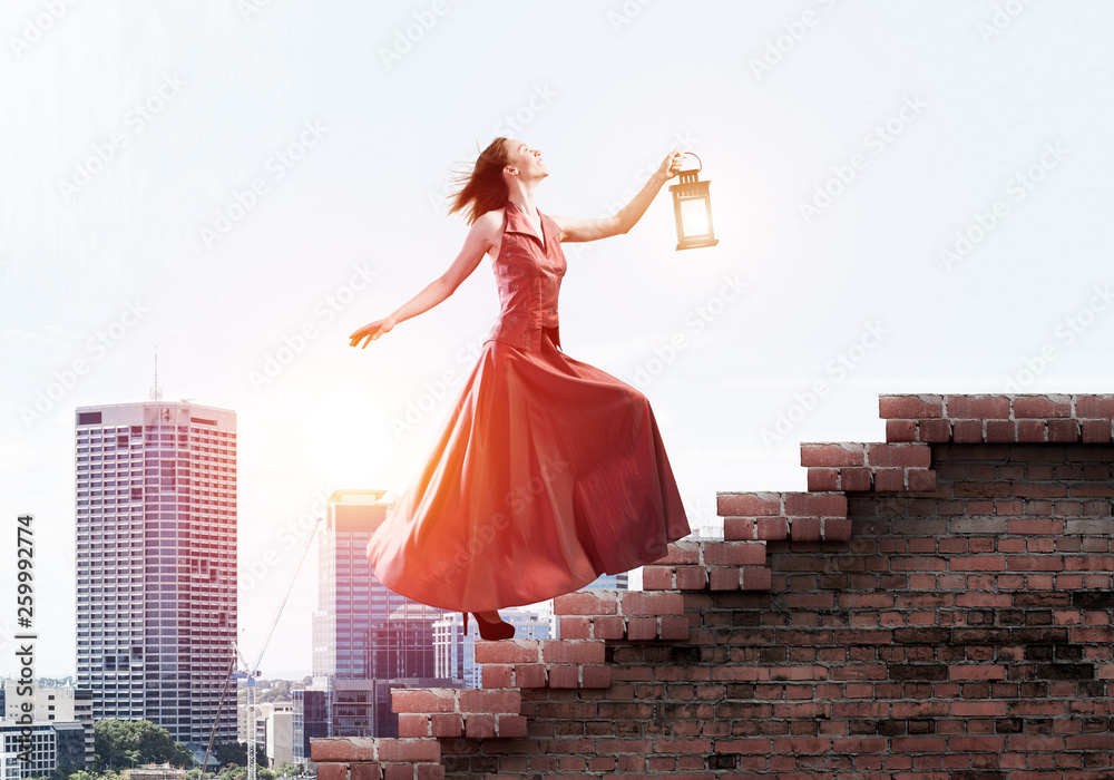 Fototapeta premium Girl in long dress going up the stairway. Mixed media
