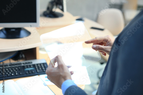 Businessman hand with transparent tablet and pc computer.