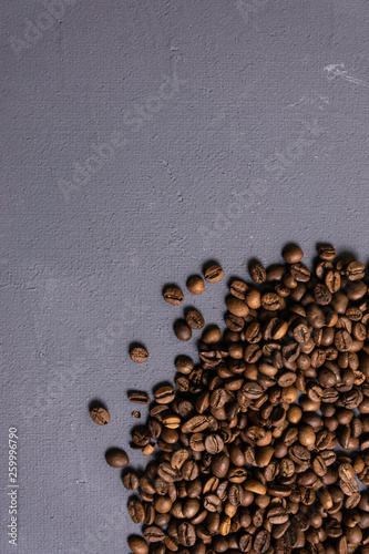 Roasted coffee beans in bulk on a gray concrete background. dark cofee roasted grain flavor aroma cafe, natural coffe shop background, top view from above, copy space