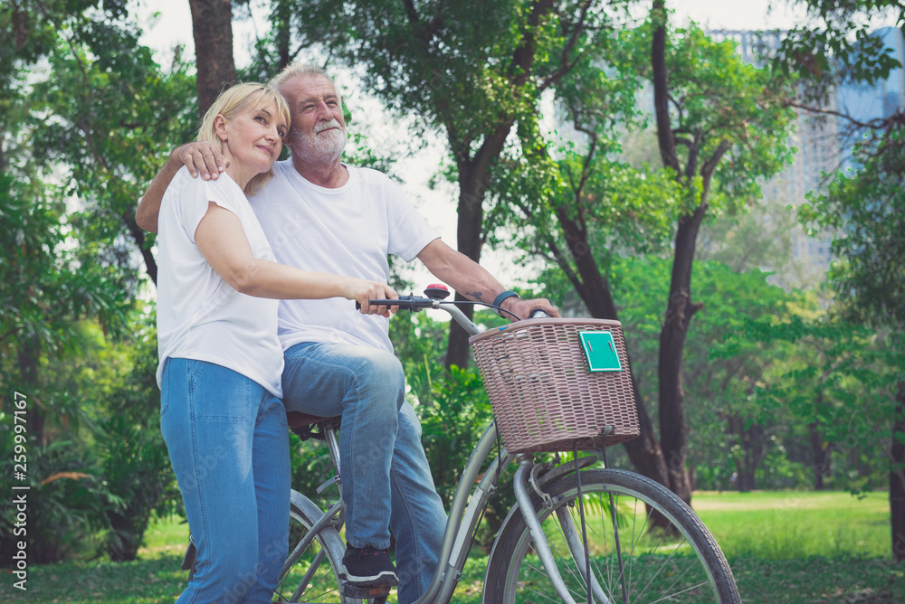 Senior Couple Riding Bikes In Park Senior Couple Riding Bikes In Park