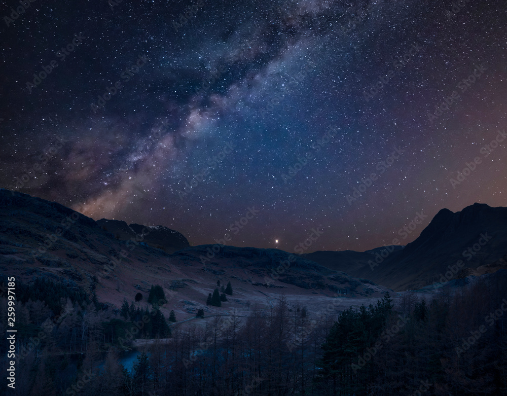 Digital composite image of Milky Way over beautiful landscape image of Blea Tarn in UK Lake District