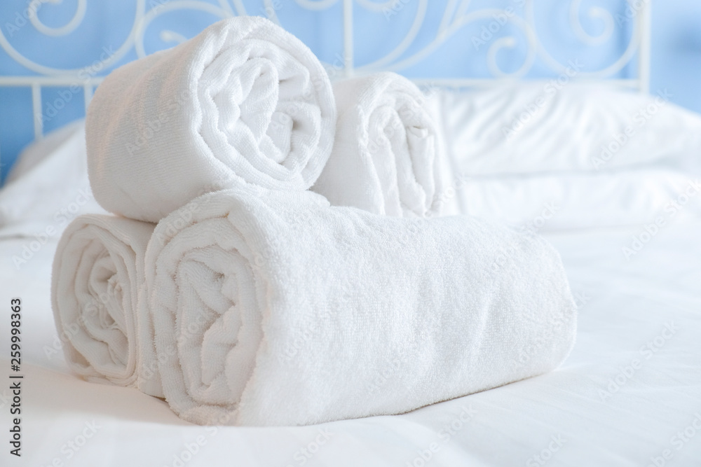 Fresh and clean nicely rolled up towels lie on a bed Fresh and clean nicely rolled up towels lie on a bed