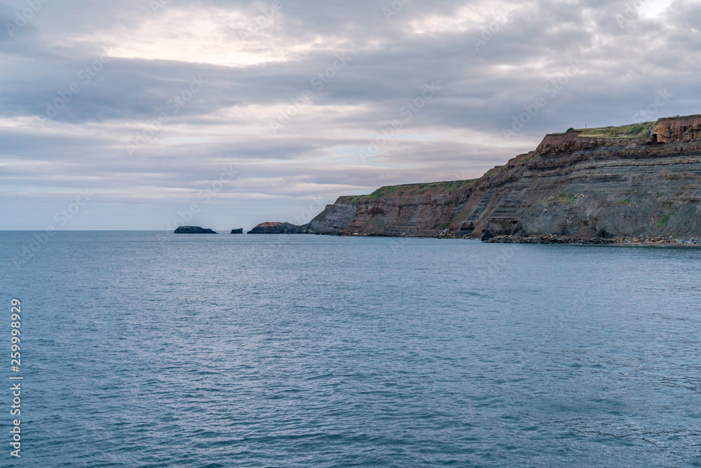 Stones and cliffs in the evening light, seen in Whitby, North Yorkshire, England, UK Stones and cliffs in the evening light, seen in Whitby, North Yorkshire, England, UK