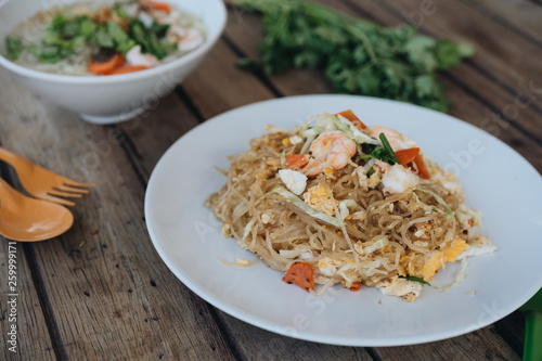 Pad Thai, stir-fried noodles in plate on the wooden table