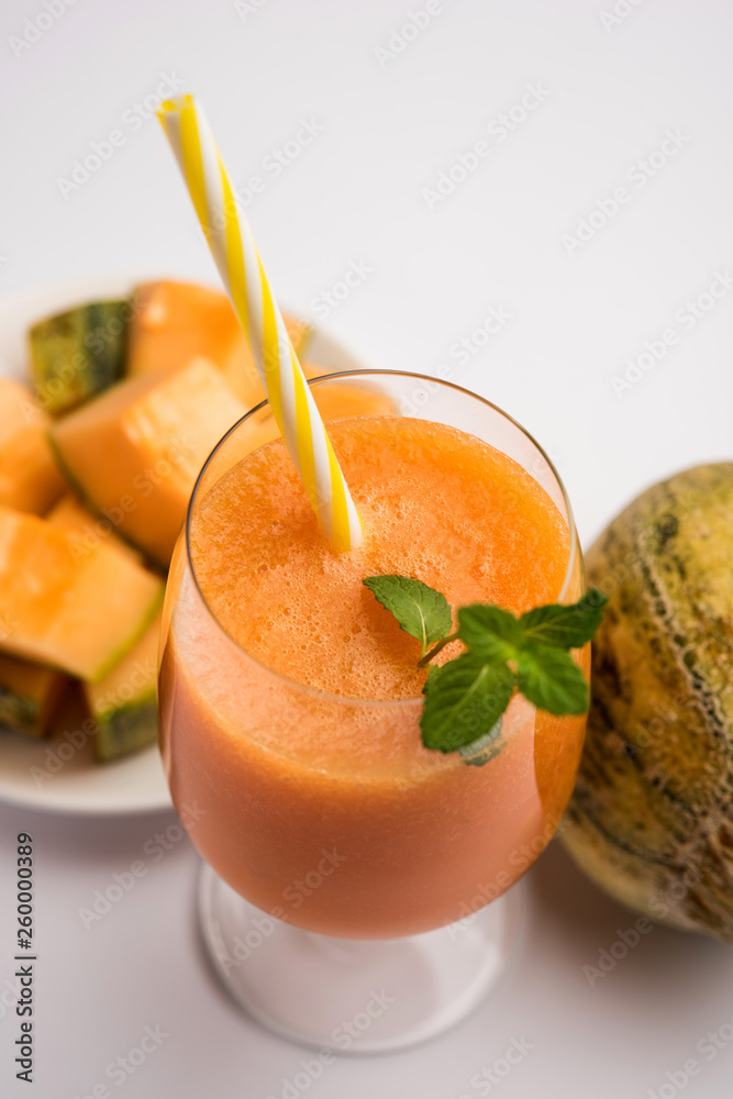 Musk melon juice with slice, also known as Kharbuj/kharbuja fruit extract, served in a glass with mint. selective focus