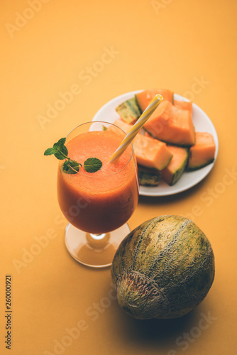 Musk melon juice with slice, also known as Kharbuj/kharbuja fruit extract, served in a glass with mint. selective focus photo