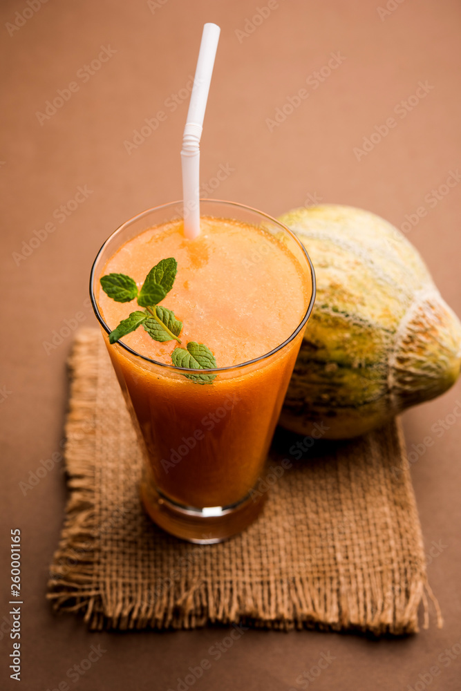 Musk melon juice with slice, also known as Kharbuj/kharbuja fruit extract, served in a glass with mint. selective focus Musk melon juice with slice, also known as Kharbuj/kharbuja fruit extract, served in a glass with mint. selective focus