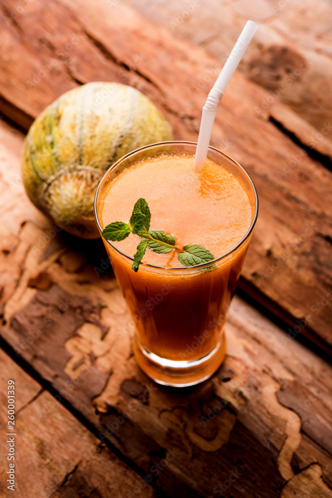 Musk melon juice with slice, also known as Kharbuj/kharbuja fruit extract, served in a glass with mint. selective focus Musk melon juice with slice, also known as Kharbuj/kharbuja fruit extract, served in a glass with mint. selective focus