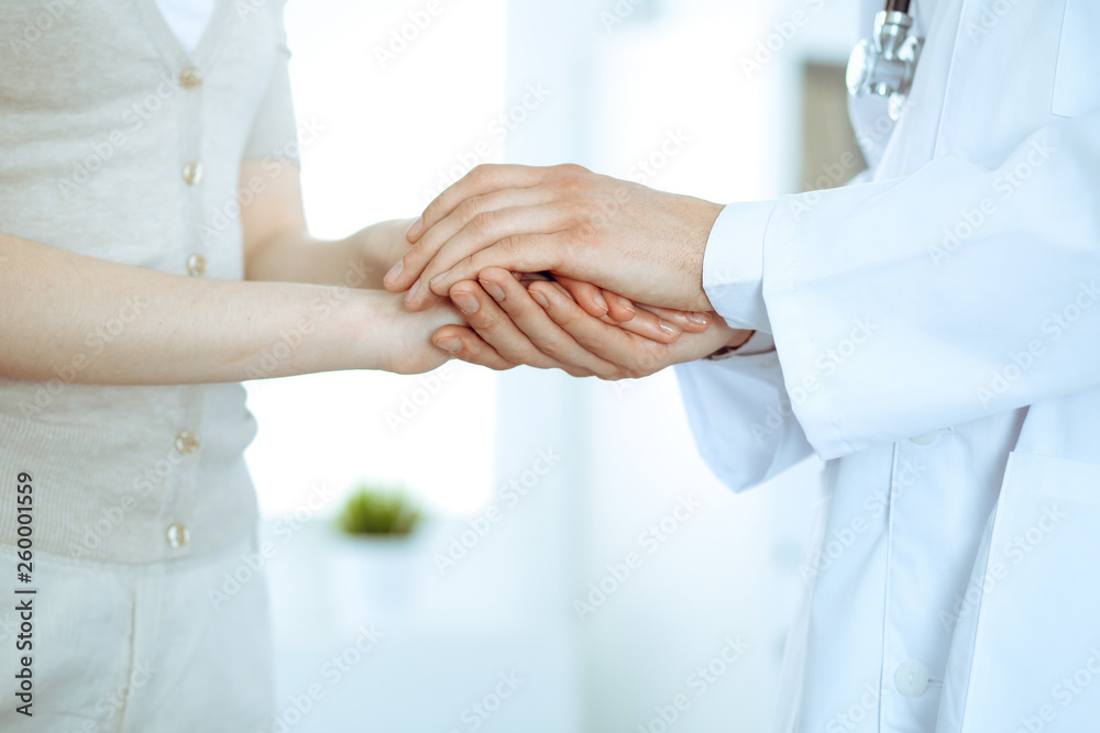 Hand of doctor reassuring her female patient. Medicine and health care concept