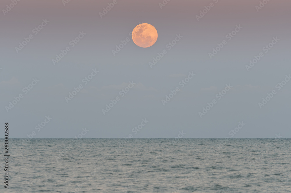 Close-up of full moon over the sea. Close-up of full moon over the sea.
