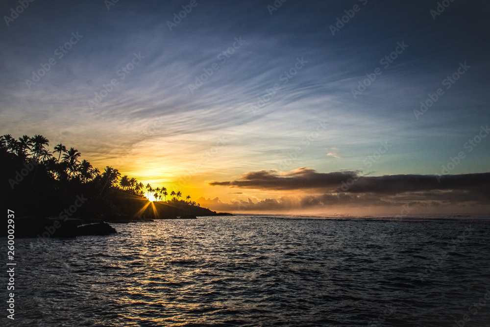 Beautiful tropical sunrise/sunset on Samoa island with palms on the background