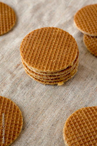 Tasty homemade dutch stroopwafels with honey-caramel filling on cloth, low angle view. Closeup.