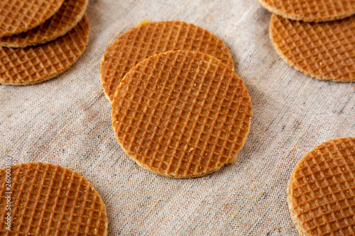 Sweet homemade dutch stroopwafels with honey-caramel filling on cloth, side view. Close-up.