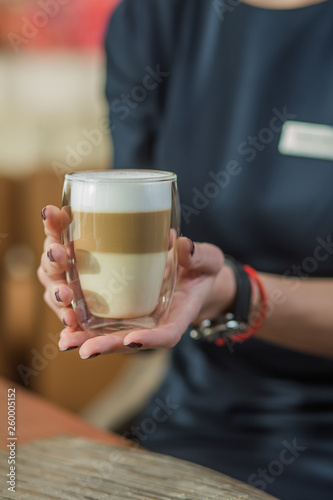 cup latte, girl barista holds a cup with latte, cup with double glass, thermoshow