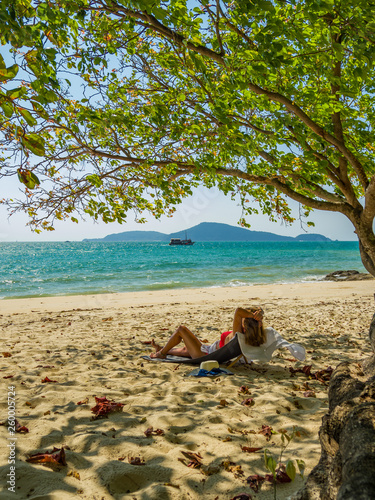 Fototapeta Naklejka Na Ścianę i Meble -  Woman enjoying her holidays on a transat at the tropical beach