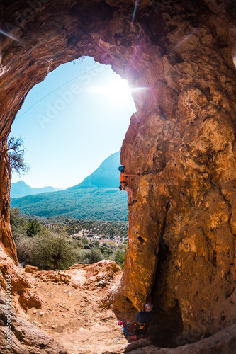 Rock climber climbs into the cave.