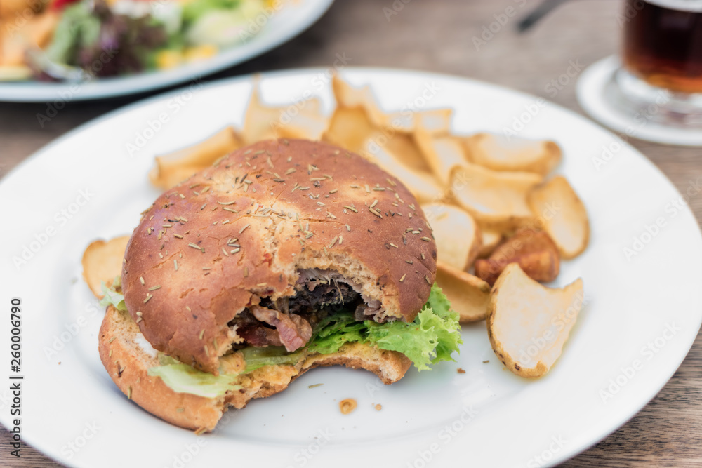 Hamburger und Kartoffelchips auf Teller, weiß