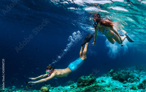Young couple snorkeling and do skin diving on the coral reef edge in tropical waters of the Maldives photo