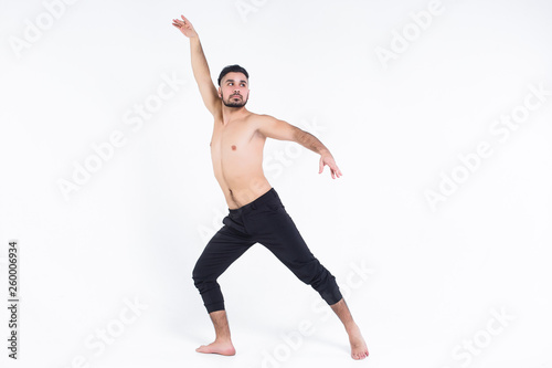 Modern acrobatic dancer posing over white background.