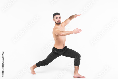 Handsome young ballet dancer on white background. Muscular sports man wearing at black pants.